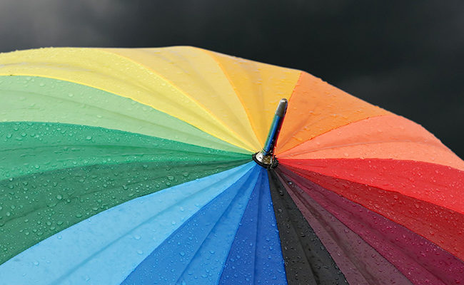 rainbow colored umbrella’s in heavy rain to use as background or cd cover