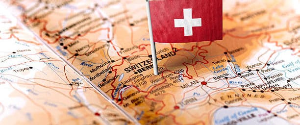 The flag of Switzerland pinned on the map. Horizontal orientation. Macro photography.